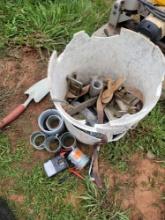 bucket of concrete working tools, straps 2in conduit couplings, garden shovel