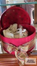 Satin wrapped container with baby shoes and baby outfit
