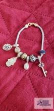 Silver and gold colored charm bracelet,...marked 925 with charms, some are marked 925 31.1 G