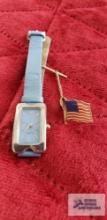 Flag pin by Park Lane and blue faced watch with blue band (Description provided by seller)