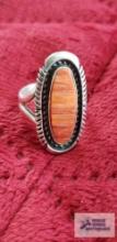 Silver colored ring with orange stone marked Sterling JJ 7.7 G (Description provided by seller)