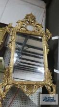 Antique mirror with ornate gold frame. Frame measures 36 in. by 24 in.