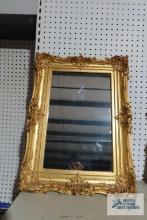 Antique mirror with ornate gold frame. Mirror measures 11 in. by 17 in. Frame measures 17 in. by...2