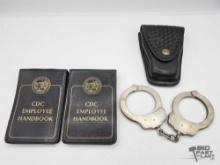 (2) CDC Employee Handbooks and Police Handcuffs with Holster