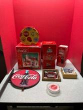 Coca-Cola collectibles, including a cast iron sign and a cabinet
