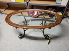 Heavy wrought iron base oval coffee table with glass top