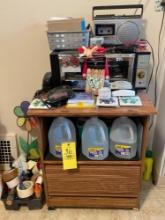 cabinet with wheels, toaster oven, radio, water jugs, alarm clock, lighters, paper plates and